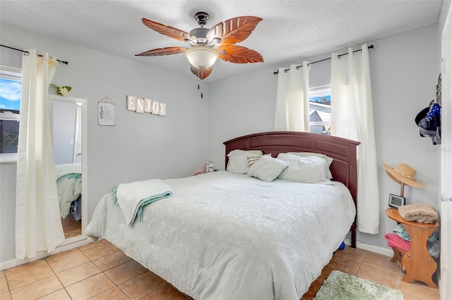 tiled bedroom with a textured ceiling and ceiling fan