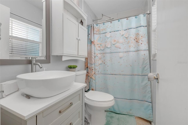 bathroom featuring vanity, curtained shower, and toilet