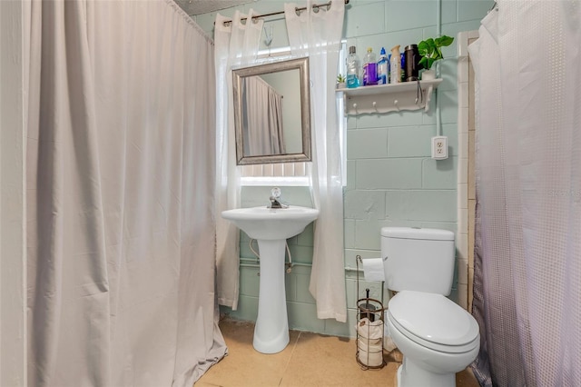 full bathroom featuring tile patterned floors, curtained shower, toilet, and tile walls