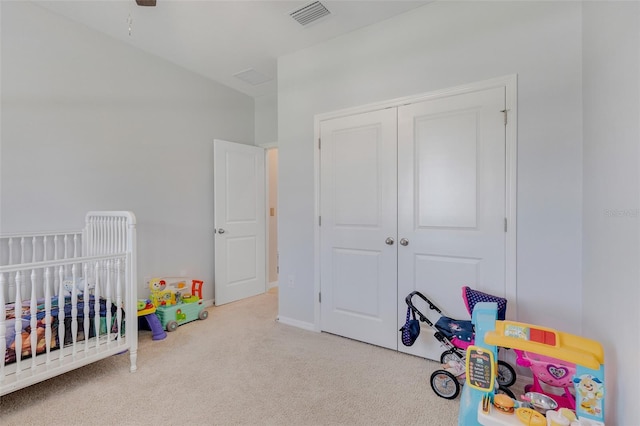 carpeted bedroom with a nursery area and a closet