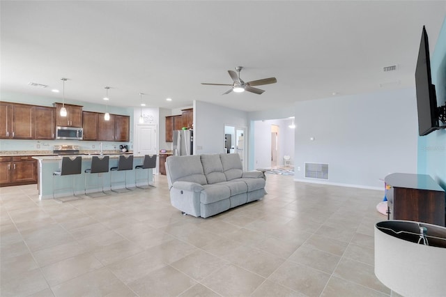 tiled living room with ceiling fan