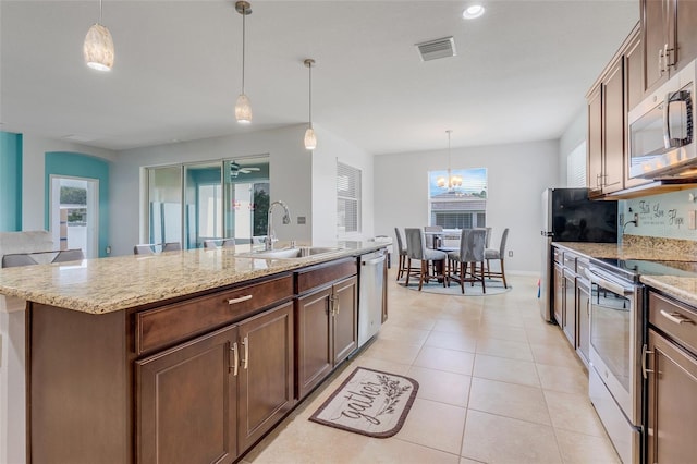 kitchen with sink, decorative light fixtures, a center island with sink, plenty of natural light, and appliances with stainless steel finishes