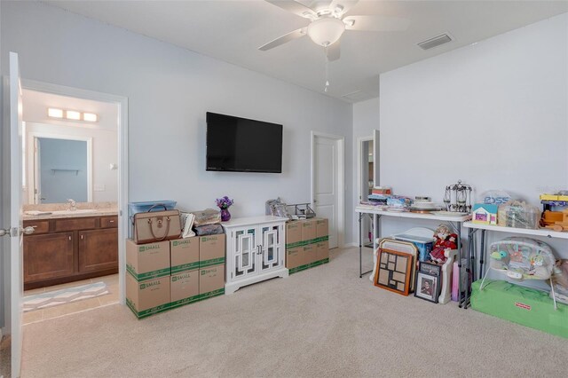 recreation room with ceiling fan, light colored carpet, and sink