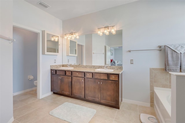 bathroom with a washtub, tile patterned flooring, vanity, and toilet