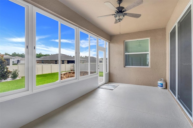 unfurnished sunroom with a healthy amount of sunlight and ceiling fan