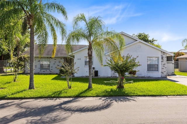 148 Merida Dr, Kissimmee, FL 34743 - view of front of property with stucco siding, a front yard, and fence