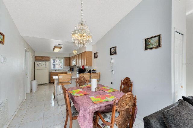 148 Merida Dr, Kissimmee, FL 34743 - dining room featuring a chandelier, visible vents, light tile patterned floors, and vaulted ceiling
