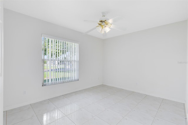 spare room with ceiling fan and light tile patterned floors