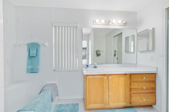 bathroom featuring tile patterned flooring, vanity, and a tub