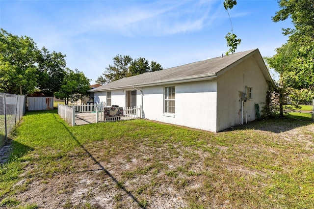 rear view of house with a patio and a yard