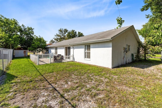 148 Merida Dr, Kissimmee, FL 34743 - back of property with a fenced backyard, a lawn, and stucco siding
