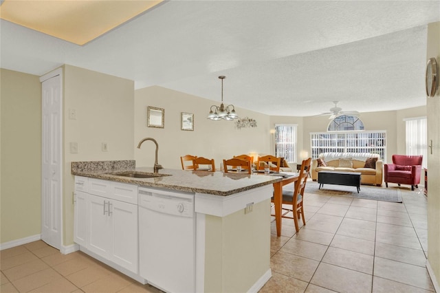 kitchen featuring sink, white cabinets, light tile patterned floors, decorative light fixtures, and white dishwasher