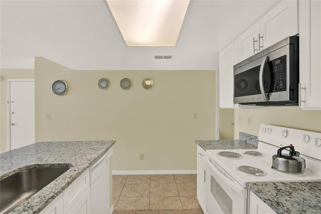 kitchen with light tile patterned flooring, white cabinets, white appliances, light stone countertops, and sink