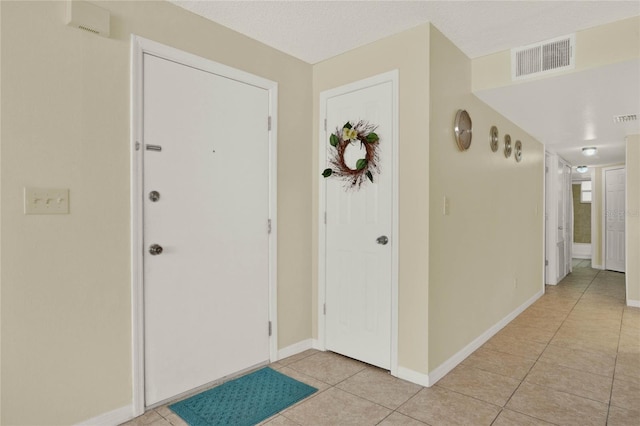 entrance foyer with a textured ceiling and light tile patterned floors