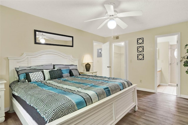 bedroom featuring ceiling fan, connected bathroom, hardwood / wood-style flooring, a closet, and a spacious closet