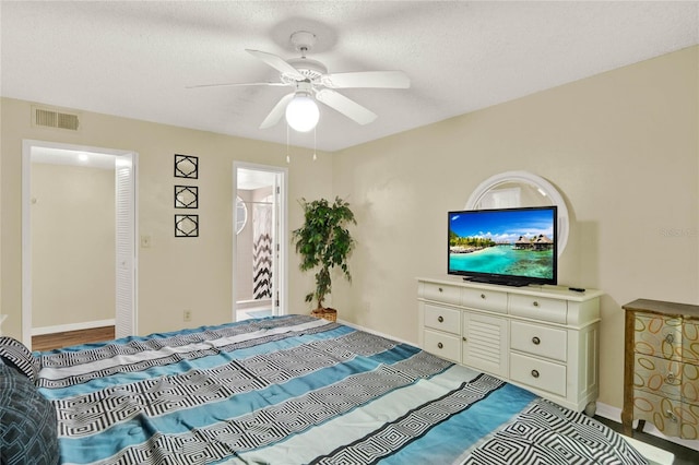 bedroom with ceiling fan, a textured ceiling, and connected bathroom