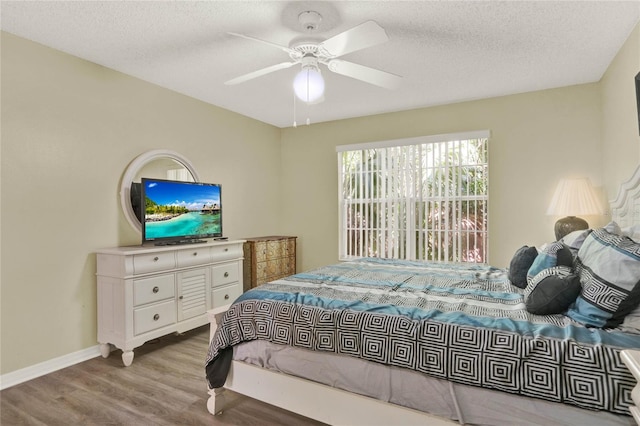 bedroom featuring light hardwood / wood-style flooring, ceiling fan, and a textured ceiling