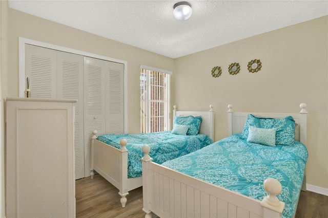 bedroom featuring wood-type flooring, a textured ceiling, and a closet