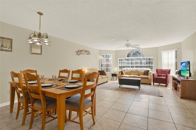 dining room featuring a textured ceiling, ceiling fan with notable chandelier, and light tile patterned floors