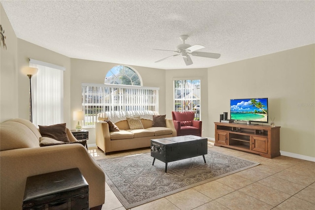 living room featuring ceiling fan, light tile patterned flooring, and a textured ceiling