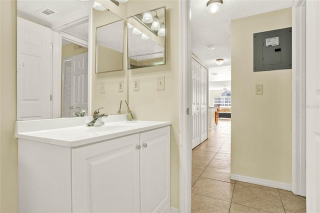 bathroom with a textured ceiling, vanity, electric panel, and tile patterned floors