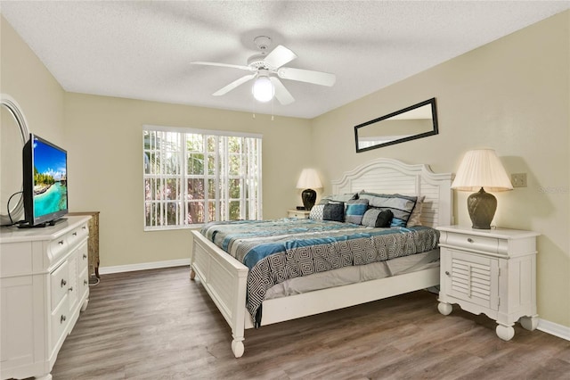 bedroom featuring a textured ceiling, dark hardwood / wood-style floors, and ceiling fan