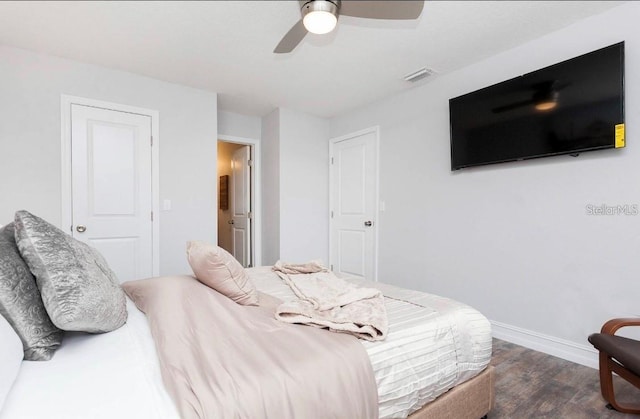 bedroom with dark hardwood / wood-style floors and ceiling fan