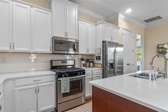 kitchen featuring crown molding, white cabinetry, sink, and stainless steel appliances