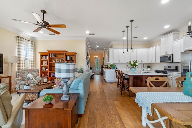 interior space with light hardwood / wood-style floors, crown molding, ceiling fan, and sink