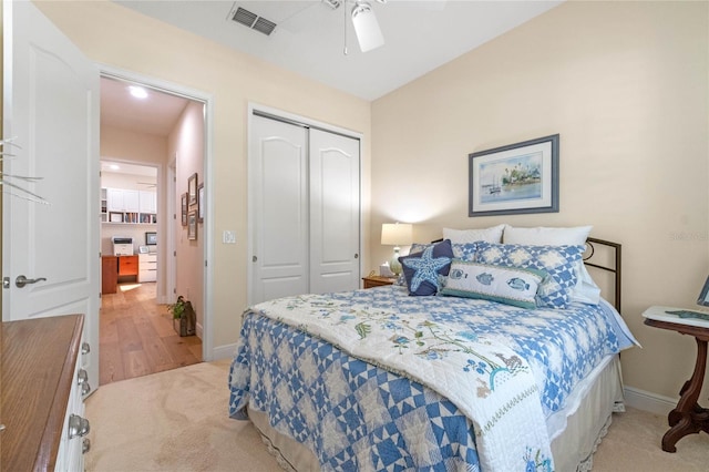 bedroom with light wood-type flooring, ceiling fan, and a closet