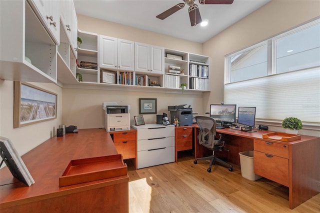 office area featuring built in desk, light hardwood / wood-style floors, and ceiling fan