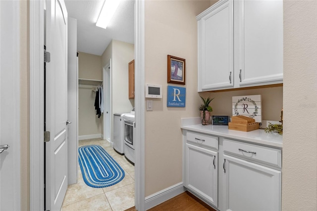 washroom with light tile patterned floors, cabinets, and independent washer and dryer