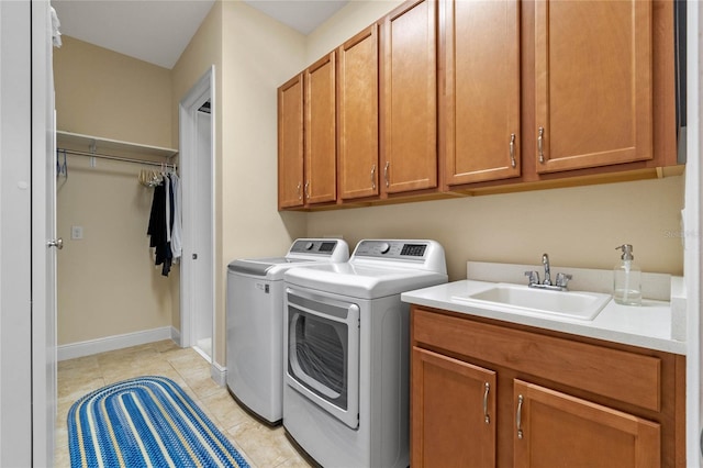 clothes washing area with light tile patterned floors, separate washer and dryer, cabinets, and sink