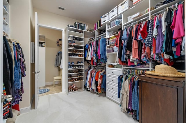 walk in closet featuring light carpet