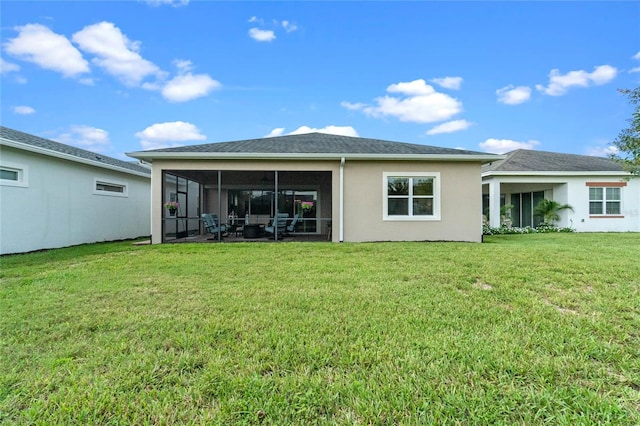 rear view of property with a sunroom and a yard