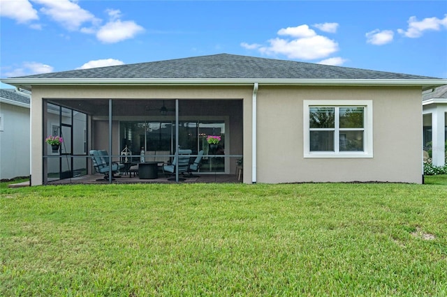 rear view of property with a patio, a yard, and a sunroom