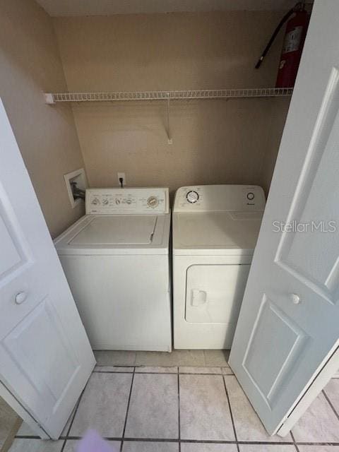 washroom featuring light tile patterned flooring and washer and dryer