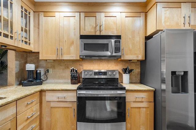 kitchen with decorative backsplash, stainless steel appliances, light brown cabinets, glass insert cabinets, and light stone counters