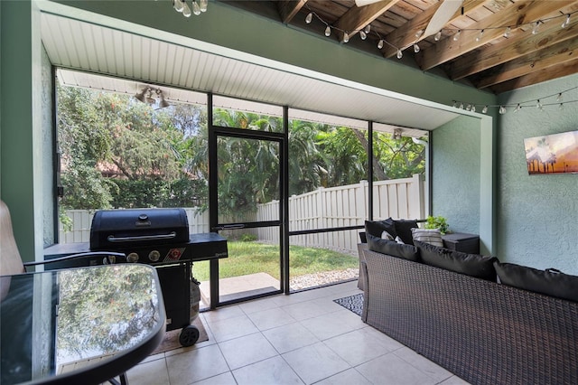 sunroom featuring plenty of natural light, beam ceiling, and outdoor lounge area