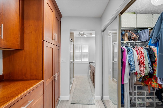 walk in closet with a ceiling fan