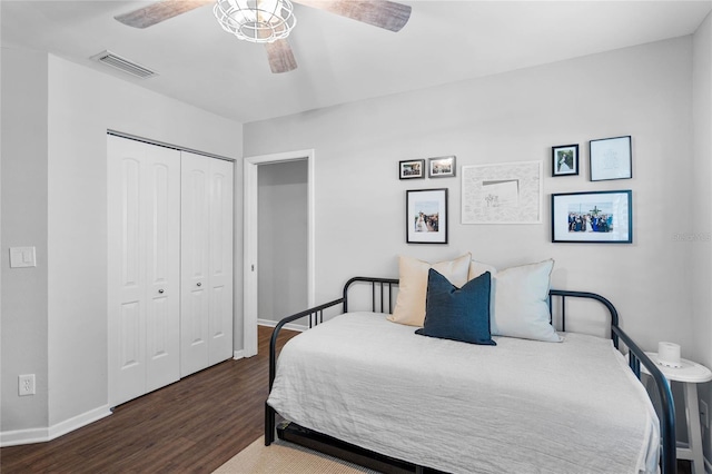 bedroom featuring a closet, visible vents, baseboards, ceiling fan, and wood finished floors