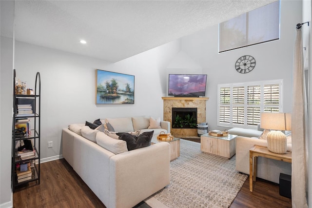 living area featuring high vaulted ceiling, a premium fireplace, baseboards, recessed lighting, and dark wood-type flooring