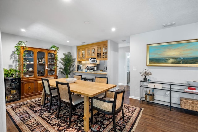 dining space featuring dark wood finished floors, baseboards, visible vents, and recessed lighting