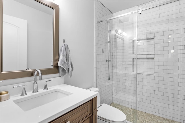 bathroom featuring a shower stall, toilet, and vanity