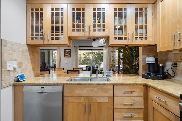 kitchen with decorative backsplash, a sink, stainless steel dishwasher, and light brown cabinetry