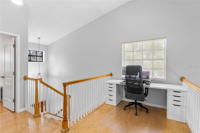 office with lofted ceiling and light wood-type flooring