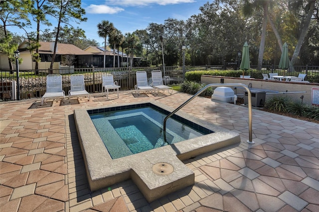 view of swimming pool with a patio, fence, and a hot tub