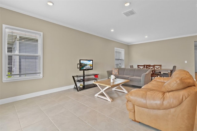 tiled living room featuring ornamental molding and a healthy amount of sunlight