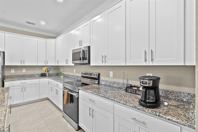 kitchen with light stone counters, white cabinets, appliances with stainless steel finishes, light tile patterned floors, and crown molding