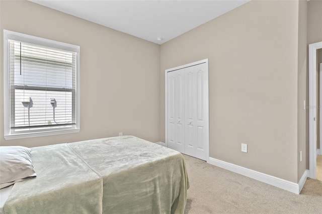 bedroom with a closet and light colored carpet